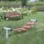Outdoor playground equipment Bridge with red stepping boards on grass.