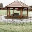 Firehouse playground shelter with wooden benches in a snowy garden.