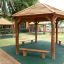 Outdoor wooden pavilion 'Firehouse' with benches under a shaded area.