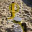 Yellow spring-based Yacht Swing rocking on sandy playground.