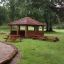 Wooden Firehouse play structure with picnic benches on a grassy playground.