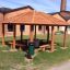 Wooden gazebo Firehouse in front of brick buildings.
