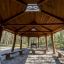 Wooden outdoor pavilion Long Firehouse with benches in forest setting
