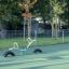 Seesaw on a playground with green surface surrounded by trees