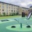 SeeSaw on a modern playground with slides and climbing structures.