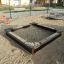 Sandbox Nature playground with wooden edges and sand inside.