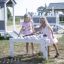 Two girls playing with Sand Pavilion Nature single playhouse at a playground.