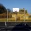 Outdoor multi-sport court with a basketball hoop and Santiago Bernabeu metal fence