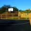 Outdoor sports court with basketball hoop and yellow fences Santiago Bernabeu.