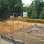 Children playing basketball on Santiago Bernabeu sports court surrounded by orange fencing.