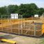 Outdoor playground Santiago Bernabeu with yellow fencing and basketball hoops.