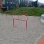 Red playground equipment bars on a sandy surface – Double Somersault.