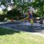 Children playing on a Triple Somersault playground equipment in a park.