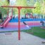 Youth Double Swing on a playground with colorful equipment.