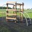 Sherwood wooden playhouse with climbing frame and ladder on a grassy playground.