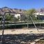 Silver Double Swing set in a playground with mountain backdrop