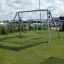 Silver Double Swing set on a grassy area near a marina