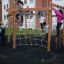 Children playing on Yellowstone wooden playhouse in playground.