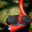 Red Seesaw seat close-up on a grassy playground.