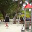 Ladybird playhouse with slide in a tropical outdoor playground