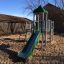 Steel structure Beetle playhouse with slide on sandy playground.
