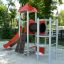 Beetle playhouse with slide, steel structure in a playground area.
