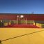 Maracana playground with red and yellow surfaces, complete with basketball court and safety fences i