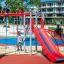 Whale steel structure playground equipment with climbing frame and red slide.