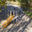 Whale steel structure playground with yellow slide and climbing frame in a park.
