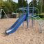 Blue Whale steel structure playground slide with climbing frame in a sandy play area.