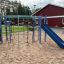 Playground equipment with climbing ropes and a blue slide.