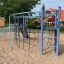 Whale steel structure playground equipment with climbing ropes and ladders on a sandy surface.