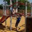 Children playing on Spider steel structure playground equipment in the park.