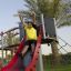 Child enjoying the Crow's Nest steel structure slide at a playground.