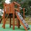 Stranda wooden playhouse with climbing wall and slide in a playground.