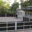 Outdoor sports field Anfield Road enclosed with black and gray panels with goal and basketball hoop.