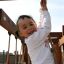 A child playing on Kampinos wooden playhouse.