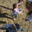 Children playing on Kampinos wooden playhouse climbing net.
