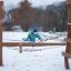 Child playing on a rope bridge at an outdoor playground during winter.