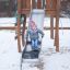 Child sliding down an Alv playground slide in winter.