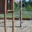 A wooden playground structure with metal climbing elements on a sandy surface from the Alv series.