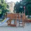 Nature Ship Sandbox, wooden playhouse with slide and climbing structure in a playground.