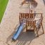 Wooden Nature Ship Sandbox playhouse with slide in a playground.