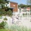 Nature Ship Sandbox, wooden playhouse in a playground setting with children playing.