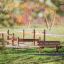Larchwood Bench in a playground with wooden climbing structures in the background.