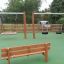 Larchwood Bench in playground with swings in the background.