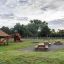 Larchwood Table & Bench in a playground with swings and slides