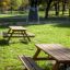 Larchwood Table & Bench in a grassy park setting.