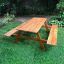 Outdoor Larchwood Table & Bench on green grass.