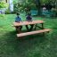 Larchwood Table & Bench in a garden setting with two people seated.